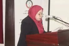 Frau (Islah Hassniyyeh) mit rotem Kopftuch am Rednerpult