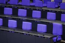 Reihen leerer Sitze mit Mikrofonen im Plenarsaal des Deutschen Bundestages.