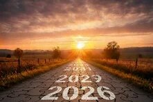 Straight road made of puzzle pieces with years 2026 to 2033, leading into a sunrise between fields and trees.
