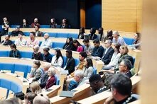 Das Foto zeigt eine mehrere Personen auf einer Zuschauertribüne.