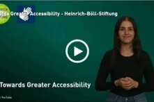 Screenshot of the first video frame. Woman gesturing "Towards Greater Accessibility"