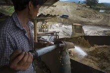 The picture shows a man operating on a mining building in the Kachin state of Myanmar.