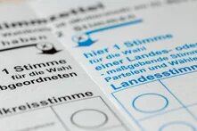 Nahaufnahme von Stimmzetteln mit Auswahlfeldern für eine Wahl, darunter Erststimme und Landesstimme.