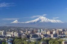 Blick über Jerewan im Frühling mit dem schneebedeckten Berg Ararat im Hintergrund und dem Opernhaus im Vordergrund.