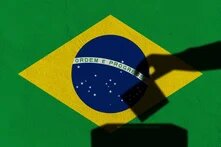 Silhouette hand election vote on Brazil flag wall background