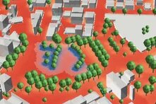 3D-Stadtansicht mit Gebäuden und vielen Bäumen. Im Zentrum liegt ein Teich, umgeben von Grünflächen und Wegen.