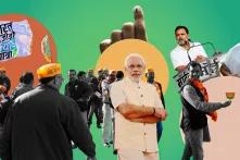Indische Politiker*innen, darunter Narendra Modi und Rahul Gandhi, auf einem grün-orangefarbenen Hintergrund. Im Hintergrund Demonstrierende und eine Hand mit Wahlmarkierung.