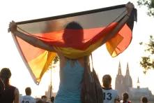 Ein Mädchen hält beim Public Viewing in Köln die deutsche Flagge empor