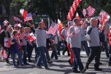 Menschen schwenken die Nationalfahnen Polens und der USA während einer Parade in New York