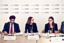 A man and two women discuss at the Munich Security Conference.