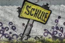 Gelbes Schild mit Aufschrift "Schule"