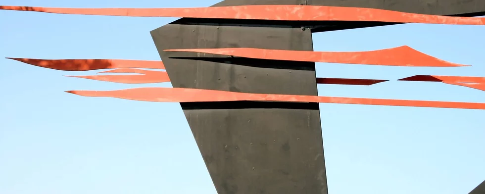 abstraktes Muster aus orange und braun vor blauem Himmel