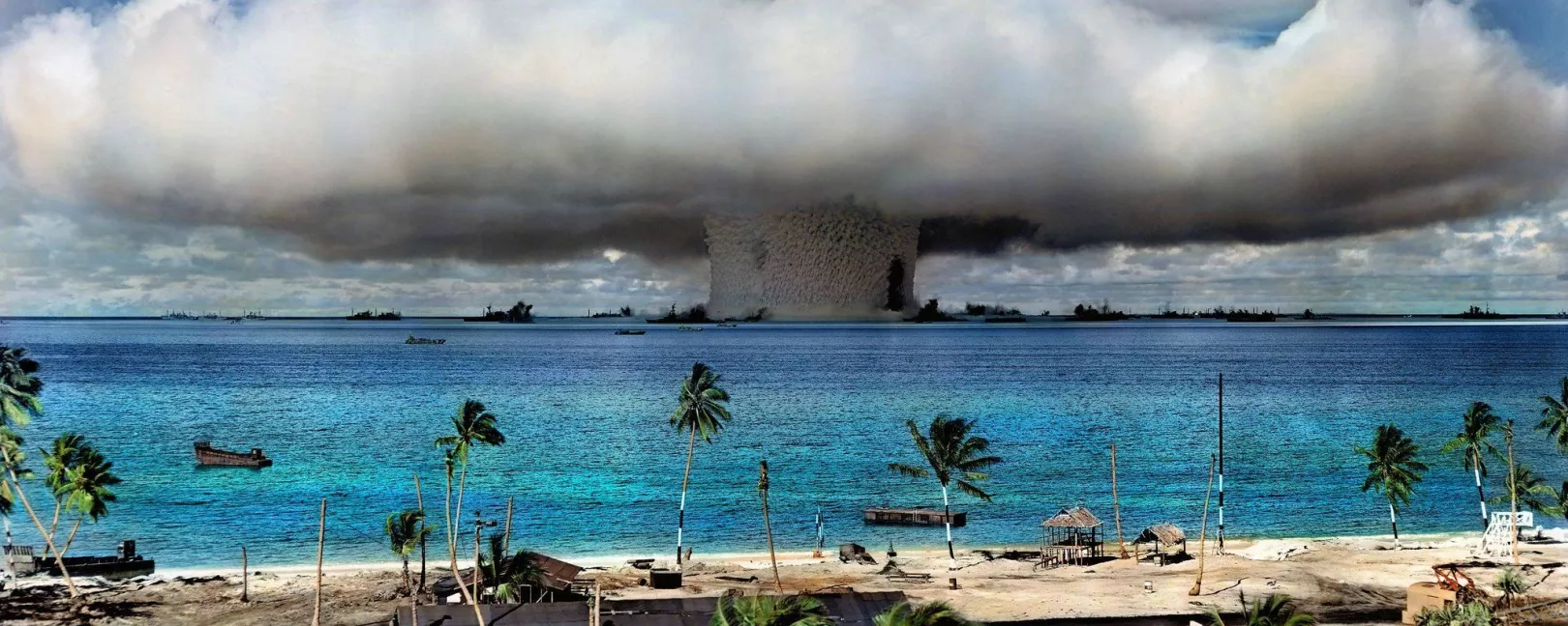 Explosion of an atomic bomb with a mushroom cloud, in the foreground beach with palm trees