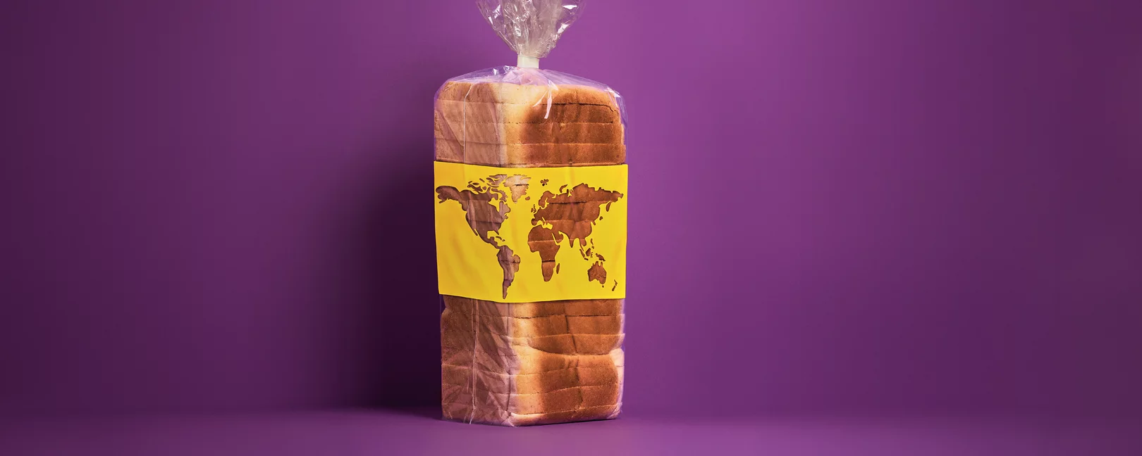 Ein in Plastik verpacktes, vorgeschnittenes Toastbrot steht vor einem violetten Hintergrund und trägt eine gelbe Banderole mit einer stilisierten Weltkarte.