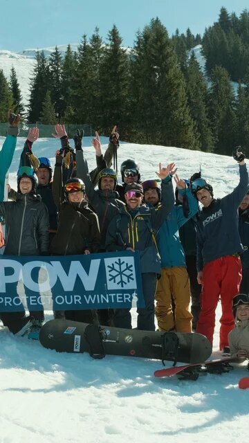 Eine Gruppe von Skifahrer*innen auf einem beschneiten Hügel.