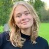 Porträt von Linda Böttcher. Sie steht auf einem Rasen und lächelt