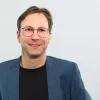 Dr. Carsten Herzberg Dr. Carsten Herzberg vor einer weißen Wand
