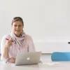 Katrin Reimer-Gordinskaya sitzt an einem Tisch mit einem Laptop vor ihr.