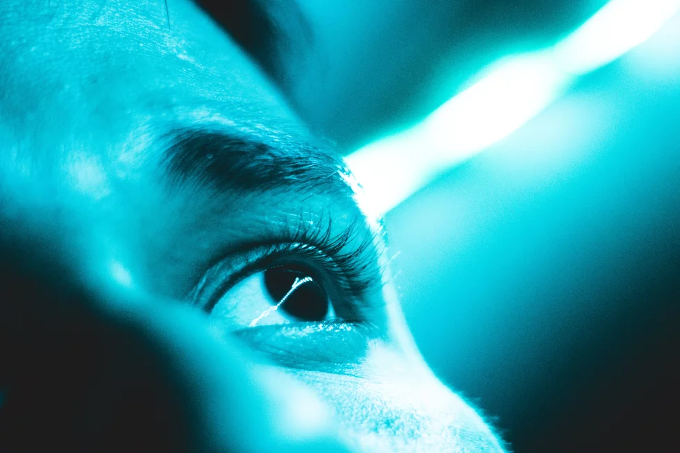 Ein Auge blickt in blaues Licht