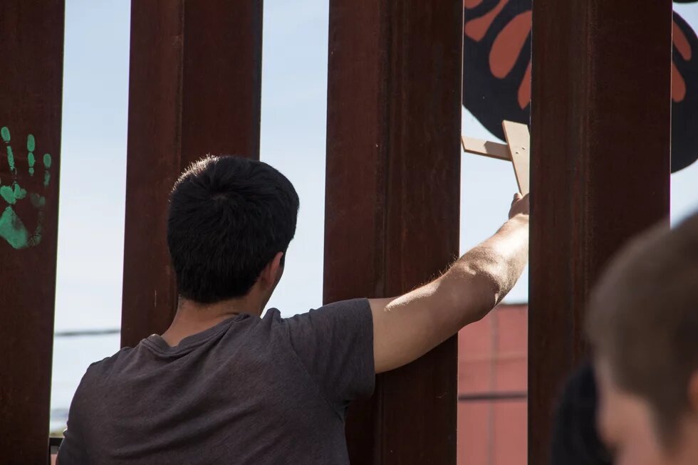 BorderEncuentro2017 Mexiko unter Präsident López _ Bild: Ein Protestant an der Grenze der USA