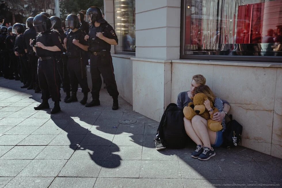 Russland 2019 «Menschen haben plötzlich Macht verspürt»: Zwei Zivilisten kauern an einer Hauswand, rechts von ihnen stehen Polizisten in Kampfmontur.