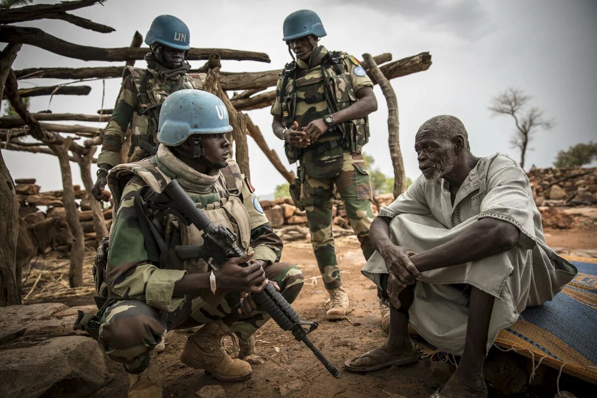 MINUSMA Soldaten Mali Die Blauhelmsoldaten umringen einen älteren Mann