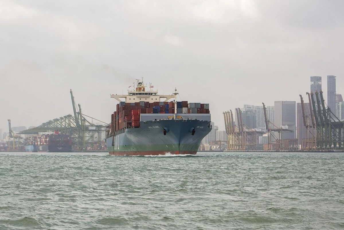 Hafen von Singapor Ein mit Containern beladenes Schiff verlässt einen Hafen