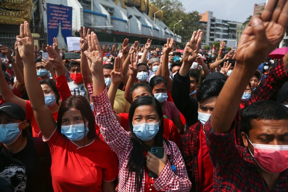 n den Tagen und Wochen nach dem Putsch im Februar kam es in Yangon und anderen Regionen täglich zu Protesten - protestierende Menschen mit erhobenen Armen und drei Finger für die Demokratie 