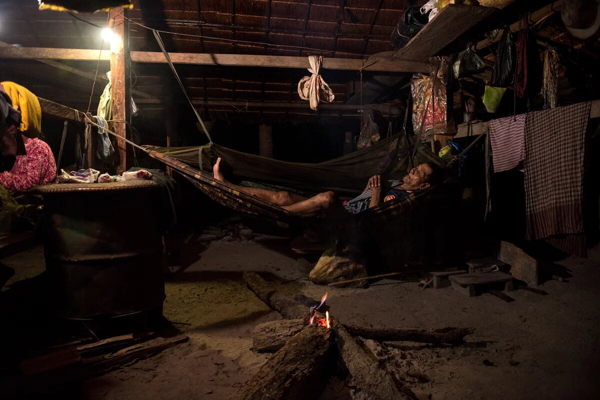 Mann liegt in Hängematte in einer Hütte im indigenen Dorf - Boeng Chhouk