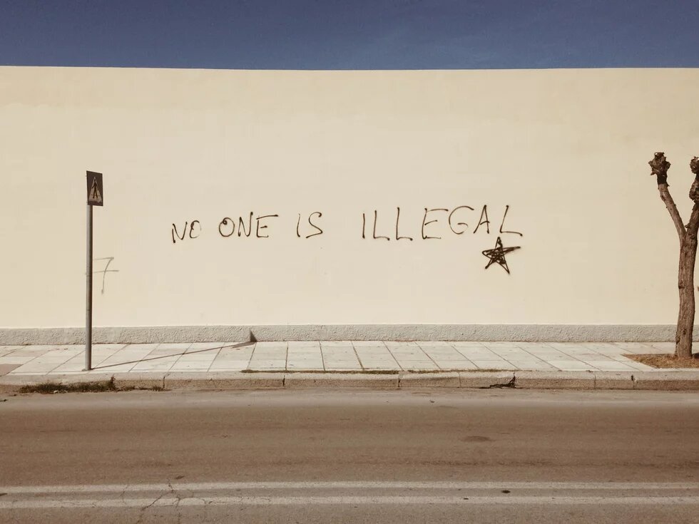 Schutzsuchende kommen nach Griechenland Eine Wand ist mit dem Satz "No one is illegal" beschriftet