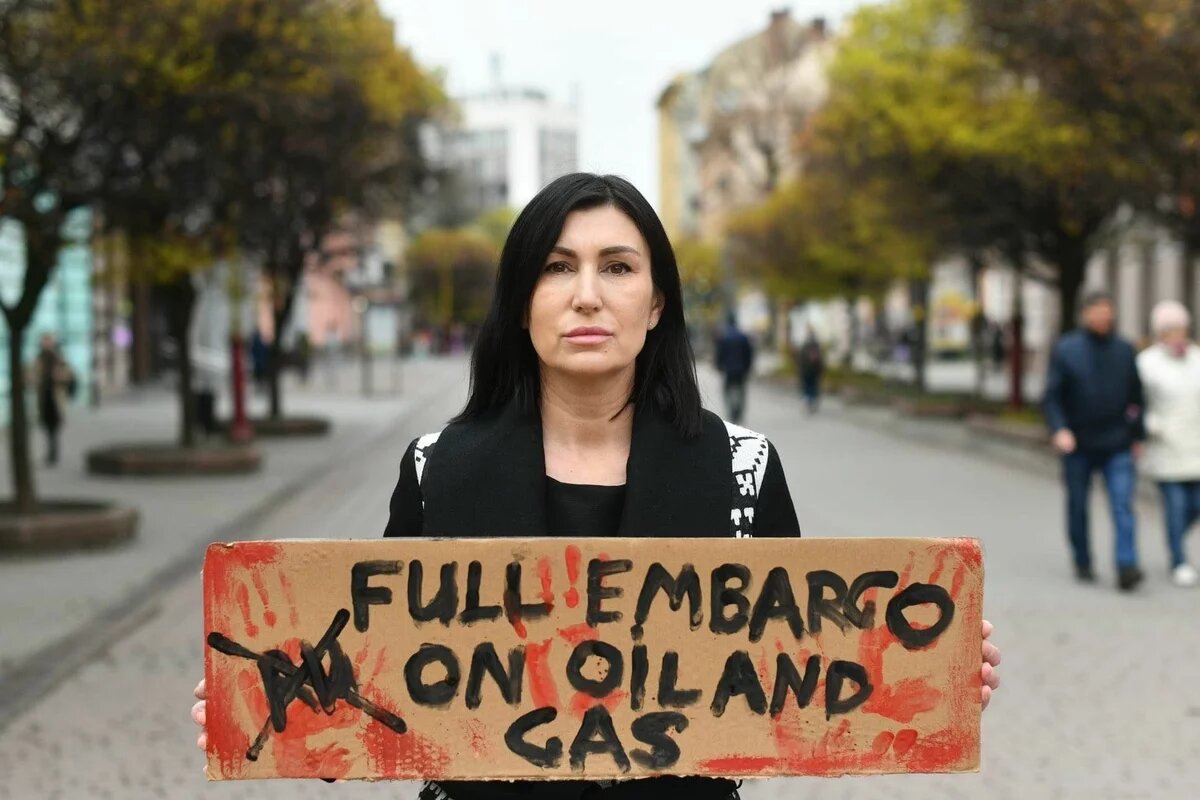 Svitlana Romanko hält ein PLakat in der Hand auf dem "Full embargo on oil and gas" steht