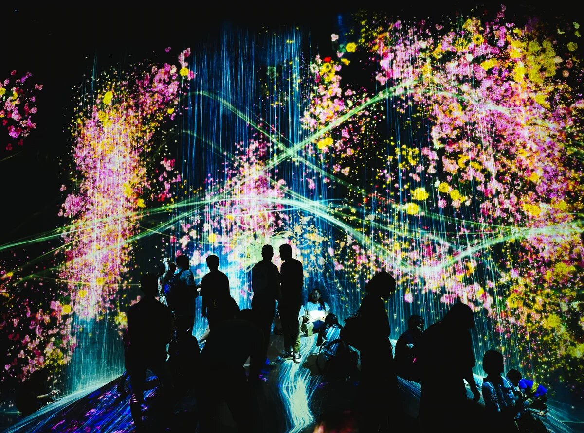 Shot in the teamLab Borderless light museum during a projection of a waterfall and neon colors in Tokyo, Japan. Aufgenommen im teamLab Borderless Light Museum während einer Projektion eines Wasserfalls und Neonfarben in Tokio, Japan.