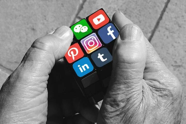 Social Media Strategy Hände halten Würfel mit Logos verschiedener sozialer Medien