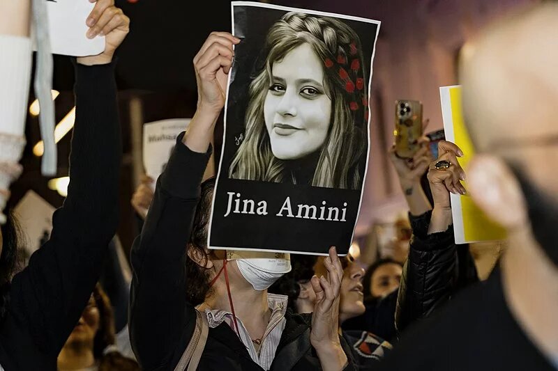 Demonstrantin mit Bild von JIna Amini Eine Demonstrantin hält ein Bild von Jina Amini hoch