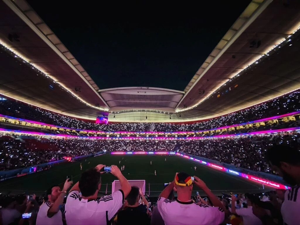 Fans in einem pink-beleuchteten Stadion