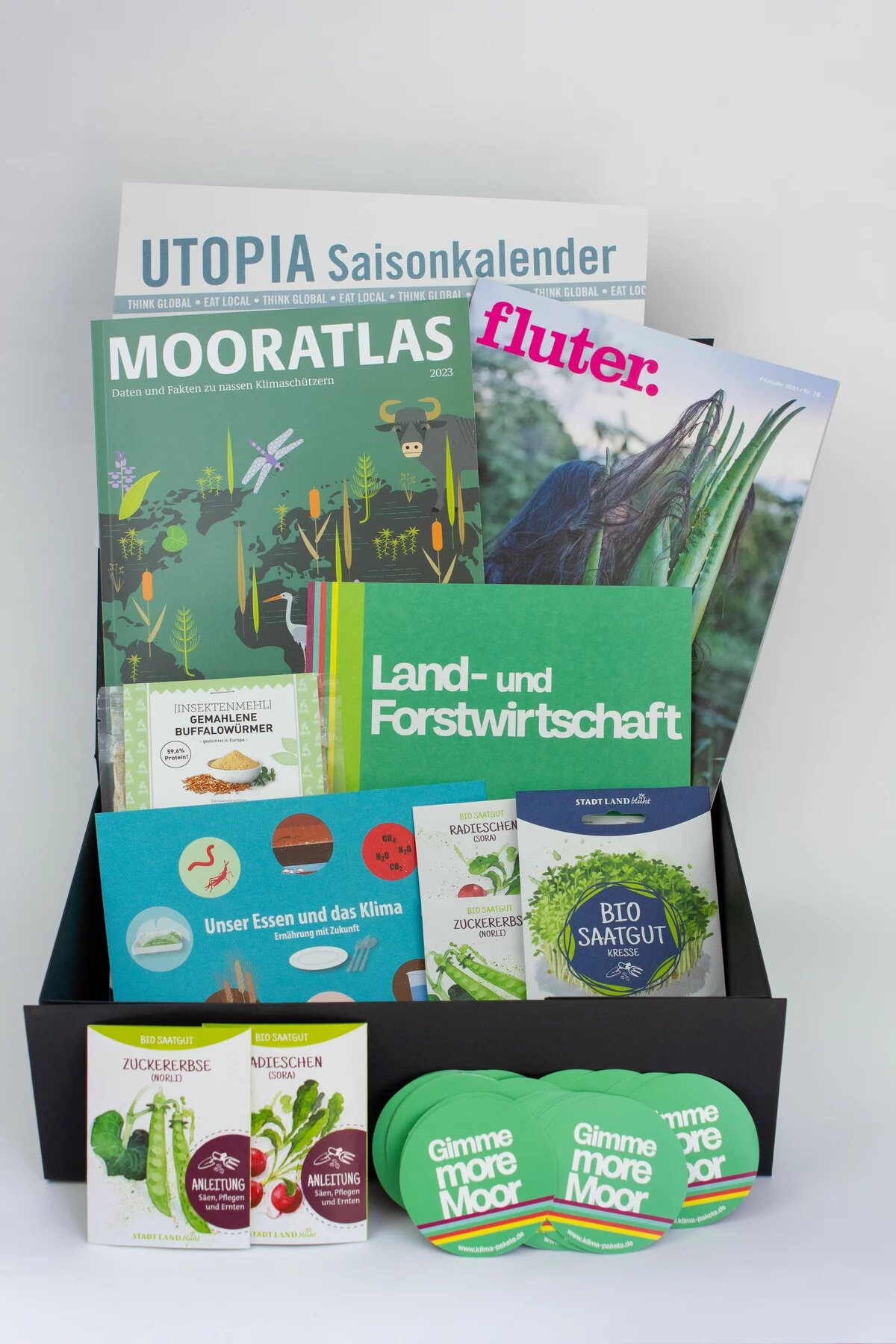 Eine offene Box mit mehren Informationsmaterialien zum Thema Land- und Forstwirtschaft, unter anderem der Mooratlas der Heinrich-Böll-Stiftung