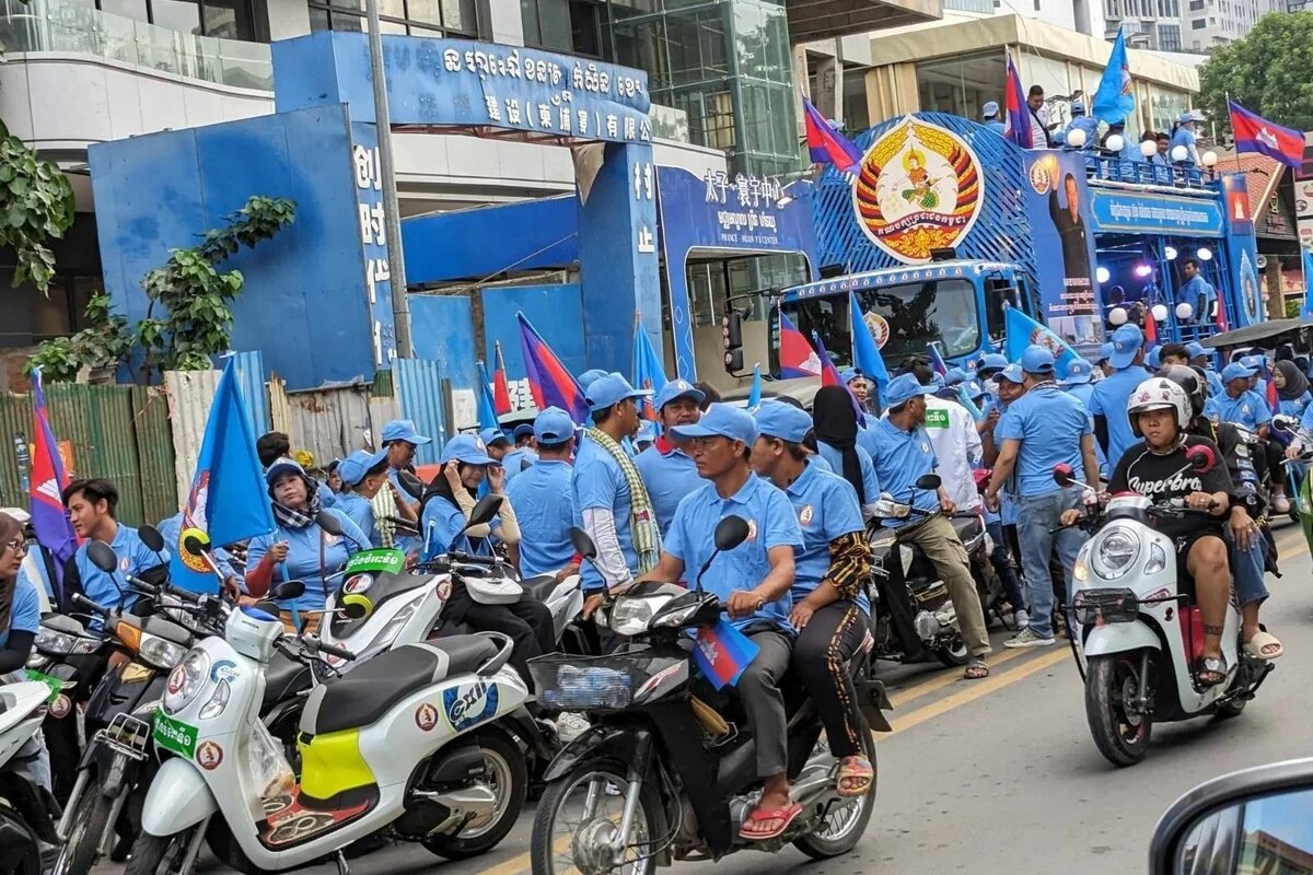 Wahlkundgebung der CPP Viele Menschen mit blauen T-Shirts und blauen Cappys auf Motorrollern