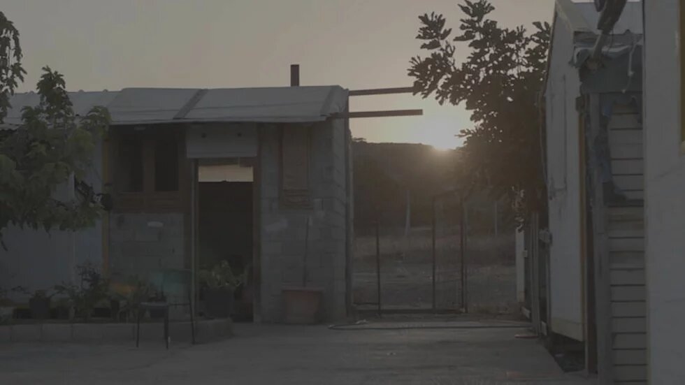 Filmstill, Lavrio Filmstill aus dem Dokumentarfilm Lavrio: Man sieht ein Haus und einen Sonnenuntergang