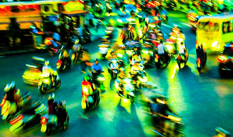 Vietnam in Motion eine belebte Straße bei Nacht, auf der viele Motorräder unterwegs sind