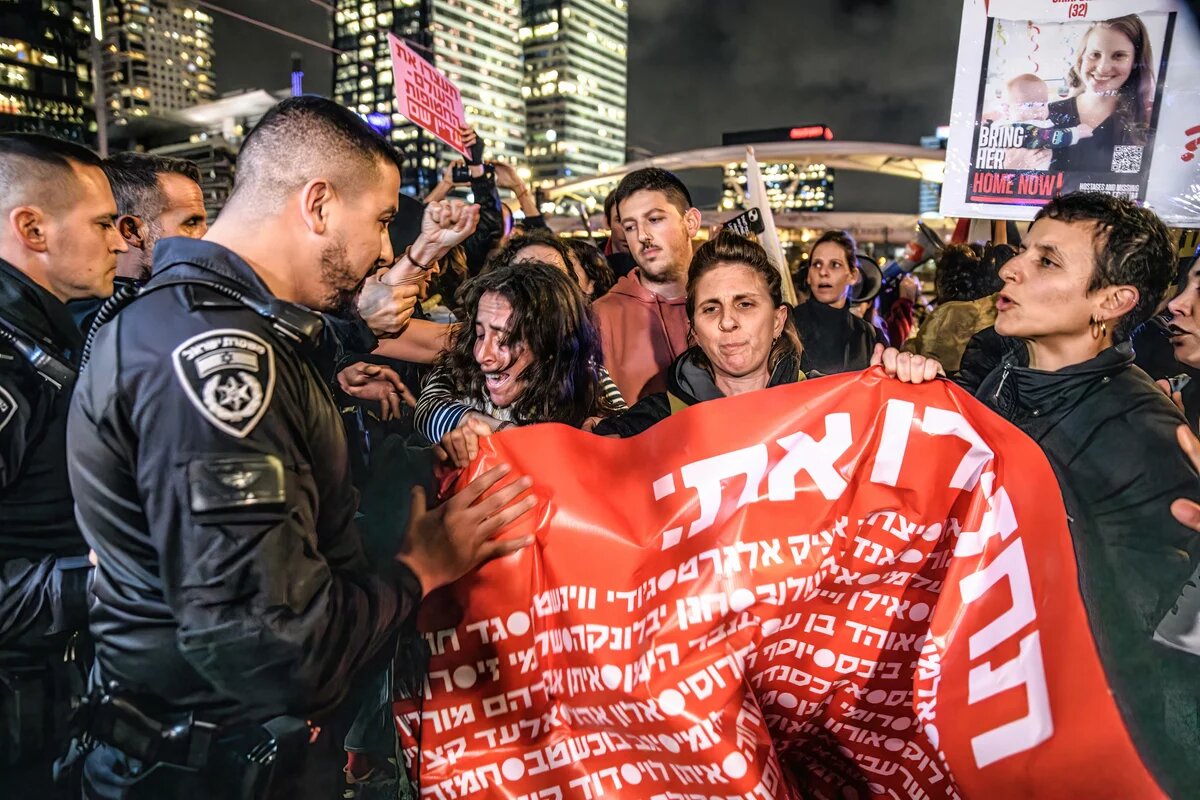 24. Januar 2024, Tel Aviv, Israel: Israelische Polizeibeamte schieben weibliche Demonstranten weg, die die Straße blockieren Tel Aviv, Israel: Israelische Polizeibeamte schieben weibliche Demonstrant*innen mit Plakat weg, die die Straße blockieren