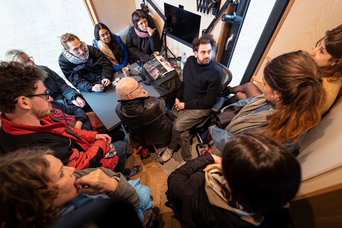Eine Gruppe von Menschen sitzt eng gedrängt im Safer Space 