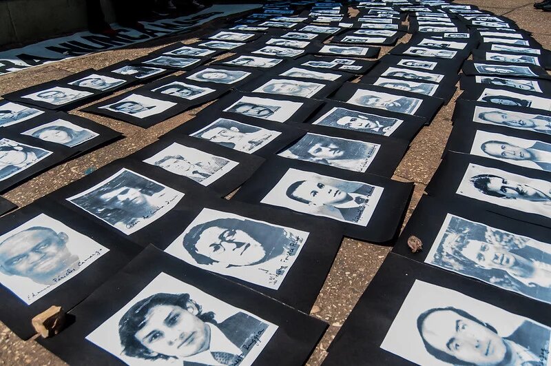 Argentinien: Bilder von Verschwundenen Auf dem Boden ausgelegte und dicht aneinandergereihte Porträts in Schwarzweißfotografie von Verschwundenen