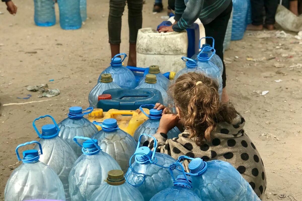 Gaza, April 2024 Child from behind with empty water bottles.