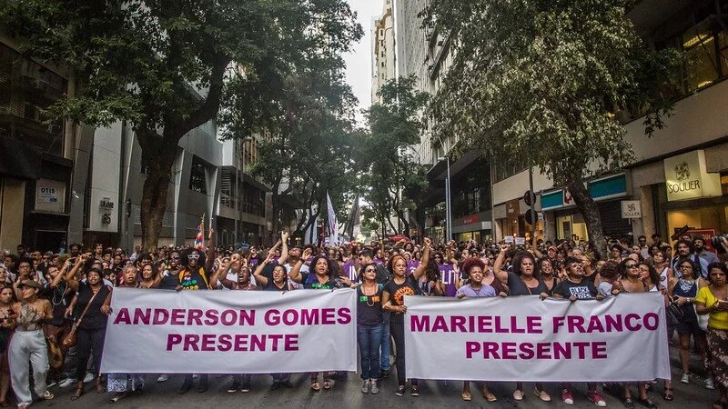 Demonstrierende in Rio de Janeiro, Brasilien. Demonstrierende die 2 Banner hochhalten, auf denen steht: "Anderson Gomes Presente" und "Marielle Franco Presente"