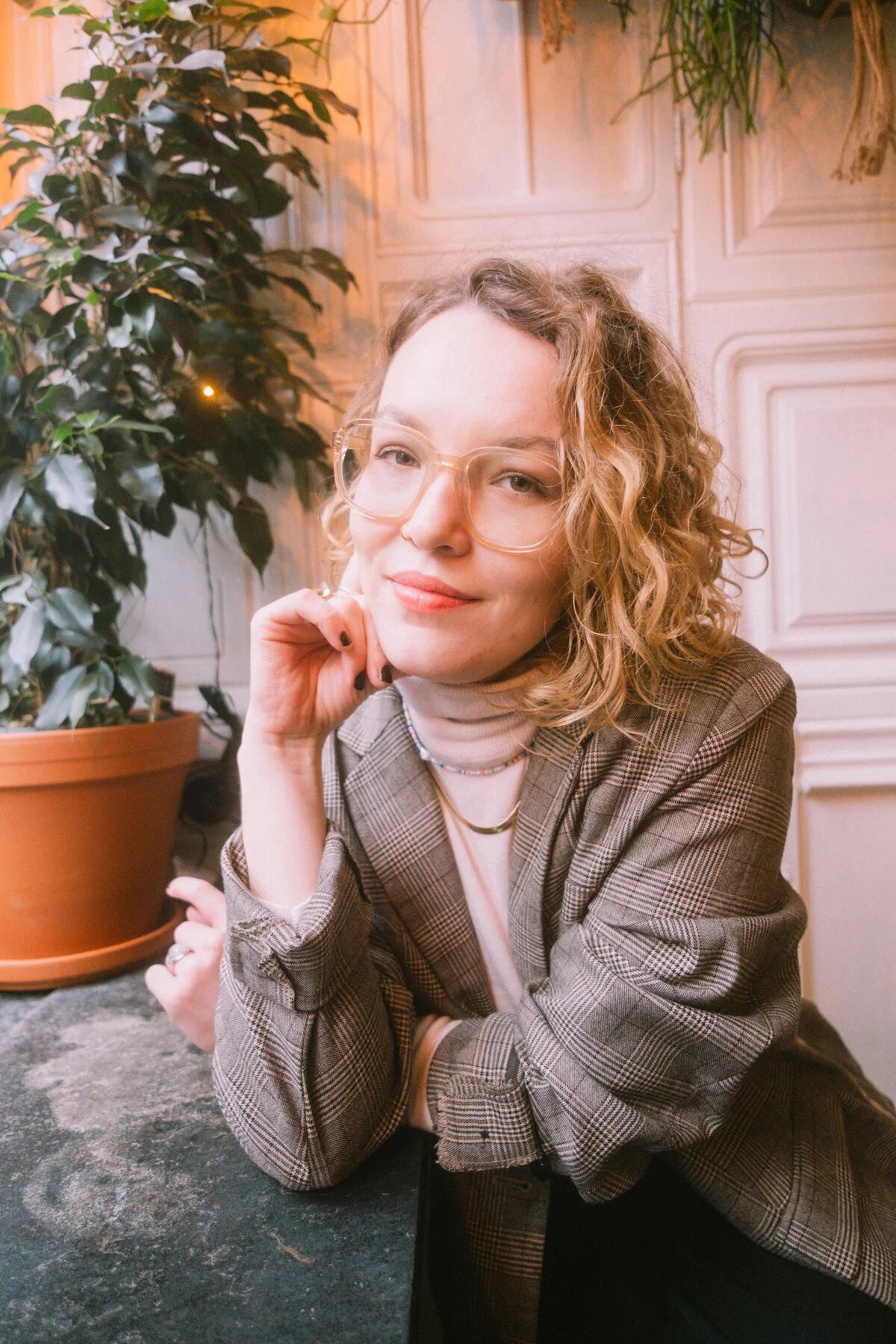 Porträt von Rike van Kleef. Eine blonde Frau mit großer Brille und Blazer lächelt in die Kamera.
