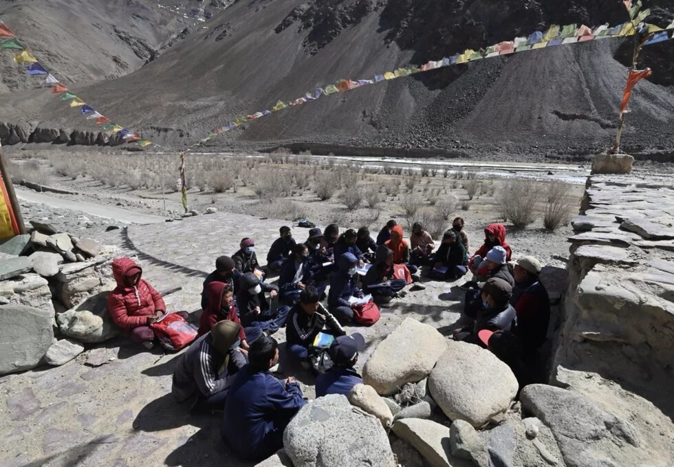 Kinder in Chumathang, Indien, sitzen am Flussufer und diskutieren über die Rechte des Flusses Indus. 