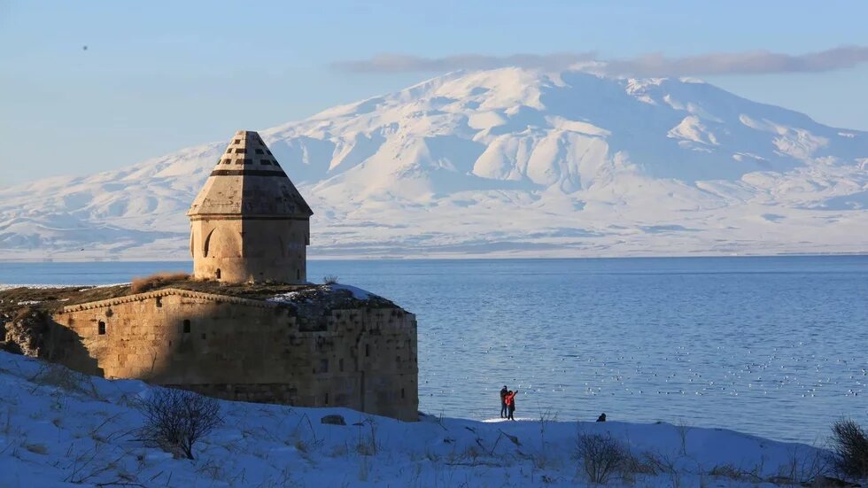 Foto: Kloster Ktuts, Van, Türkei, im Abendlicht, im Hintergrund Meer und schneebedeckte Berge.