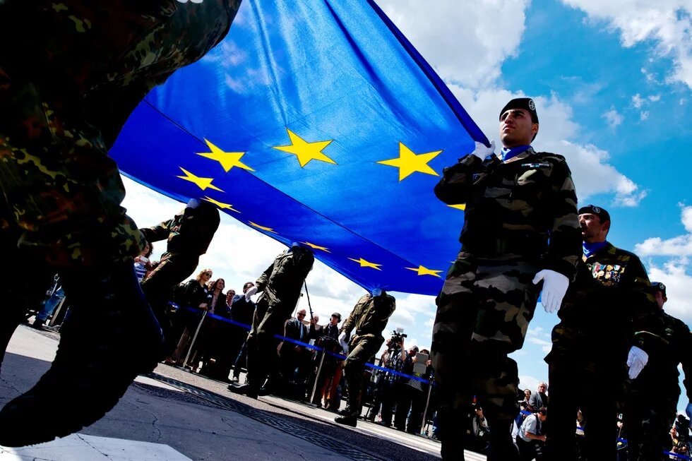 Soldaten tragen auf ihren Schultern eine große Europa-Flagge.