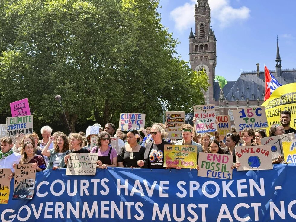 Climate protest in front of the International Court of Justice, July 2025 A group of people hold protest signs and a large banner in front of the International Court of Justice in The Hague, banner reads: "COURTS HAVE SPOKEN – GOVERNMENTS MUST ACT NOW"