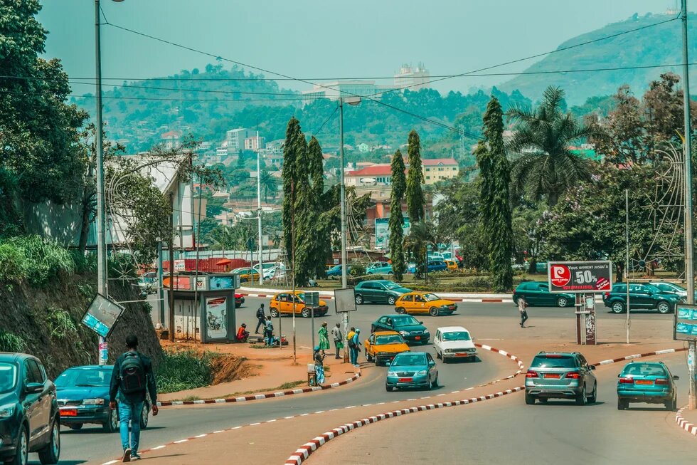 Blick auf eine talwärts verlaufende Straße in Yaoundé, Kamerun.